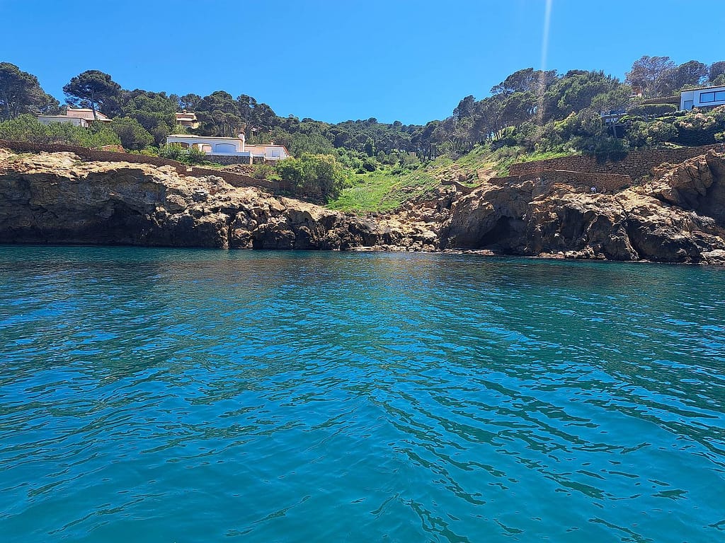 Cala de aguas cristalinas en la Costa Brava vista desde un barco en Palamós